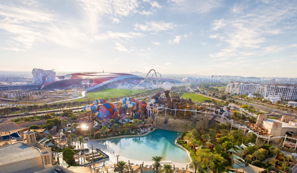 Wide view of Yas Island theme parks in Abu Dhabi with water slides, pool, roller coaster, and Ferrari World in the background