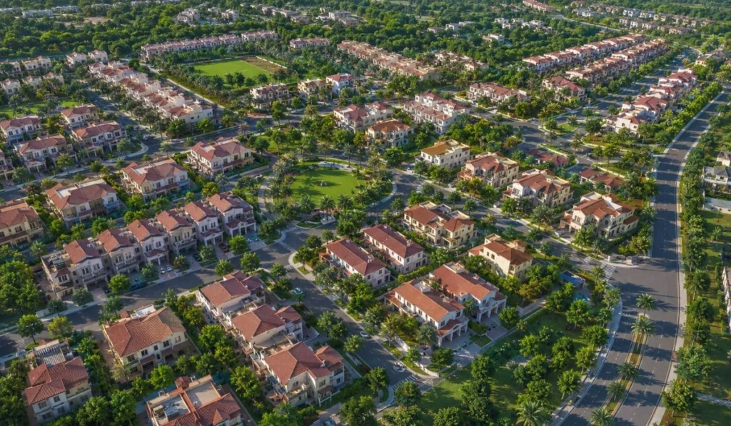 Aerial view of Green Community Village Dubai showing villas, townhouses, roads, and green landscaping