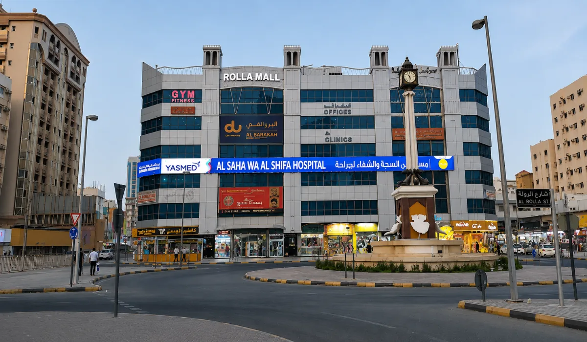 Rolla Mall building and roundabout area in Sharjah with shops, clock tower, and busy city street